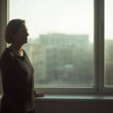 窓際に佇む中年女性