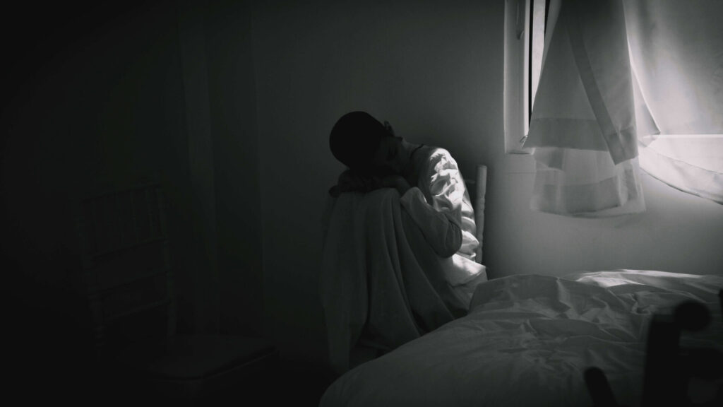 部屋でうずくまる孤独な人